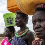 Des femmes avec des récipients d'eau à la tête au Soudan du Sud